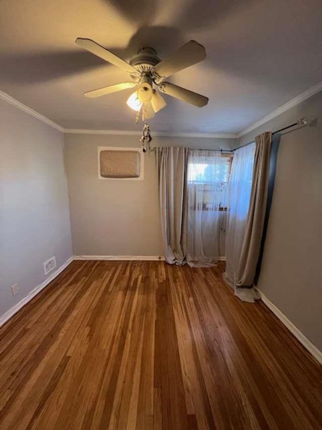 Unfurnished bedroom with visible vents, wood finished floors, crown molding, baseboards, and ceiling fan | Image 4