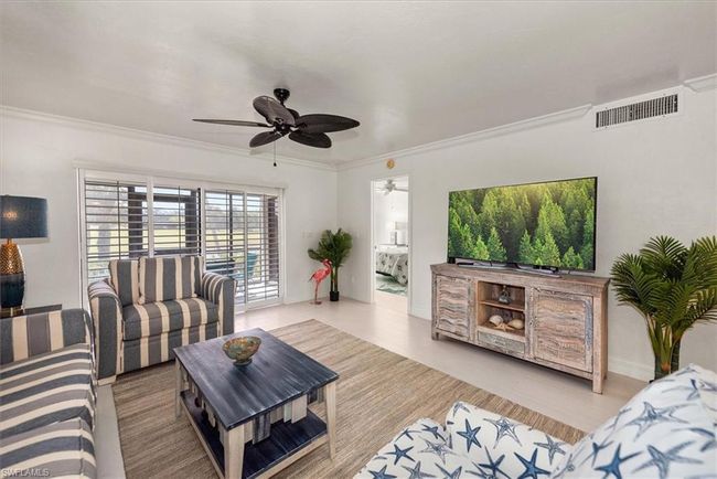 Living area featuring ornamental molding, a ceiling fan, and wood finished floors | Image 14