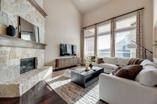 Living area featuring dark wood-style floors, a fireplace, and high vaulted ceiling | Image 8