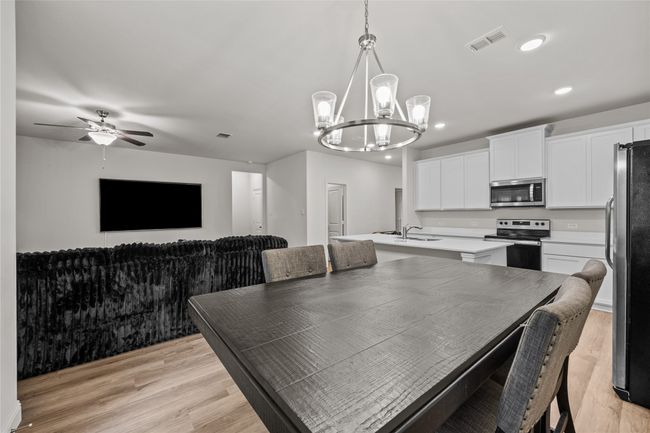 Dining area with a chandelier, light wood-style flooring, recessed lighting, and ceiling fan | Image 13