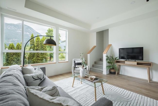 Living area featuring a tray ceiling, wood finished floors, stairs, and a mountain view | Image 10