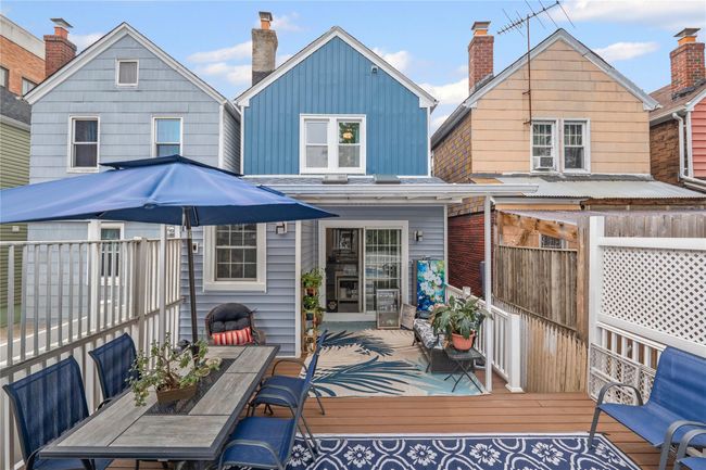 Back of house with outdoor dining area, a chimney, board and batten siding, and a deck | Image 30