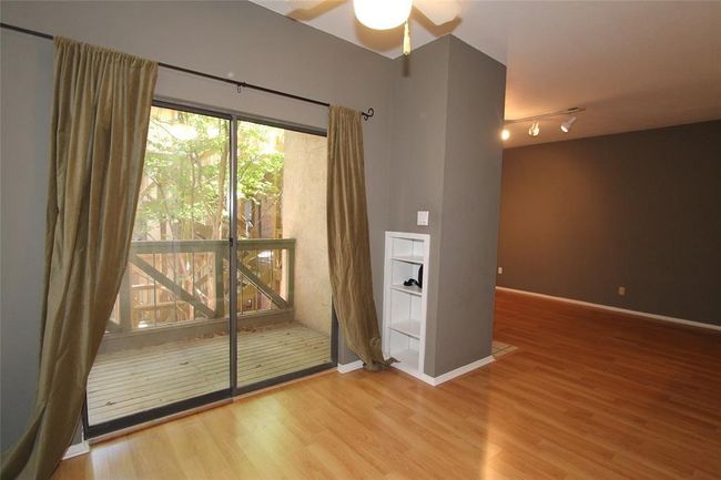 Spare room featuring wood finished floors, a ceiling fan, and baseboards | Image 4