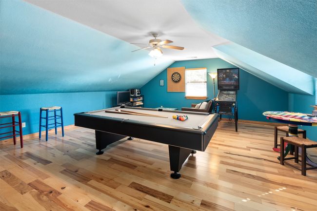 Game room featuring ceiling fan, billiards, vaulted ceiling, light hardwood / wood-style flooring, and a textured ceiling | Image 24
