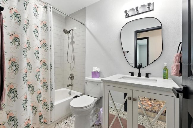 The hall bath checks all the boxes—stylish and functional with updated finishes, quartz counters, and a fun designer tile floor that gives it personality. A full tub and shower combo makes it perfect for guests, kids, or anyone who needs their own space to primp and prep | Image 39