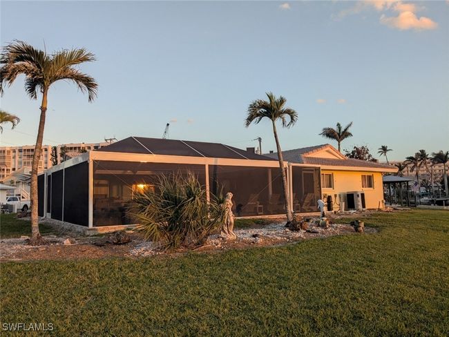 Back of property with a lanai, stucco siding, and a yard | Image 10