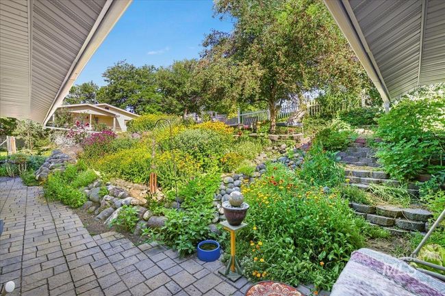 View of flower garden and patio area out back door. | Image 29
