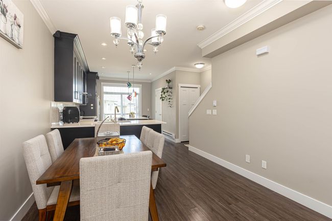 Dining area with baseboards, a chandelier, crown molding, dark wood-type flooring, and recessed lighting | Image 14