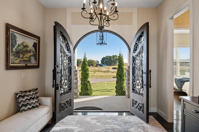 Step through stunning arched doorways into a grand foyer with elegant tile floors. | Image 4