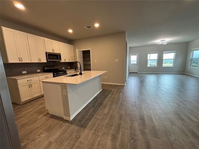 Kitchen featuring appliances with stainless steel finishes, a sink, dark wood-type flooring, baseboards, and recessed lighting | Image 6