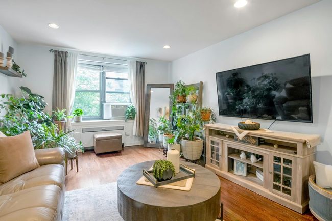 Living room with wood finished floors, cooling unit, and recessed lighting | Image 4