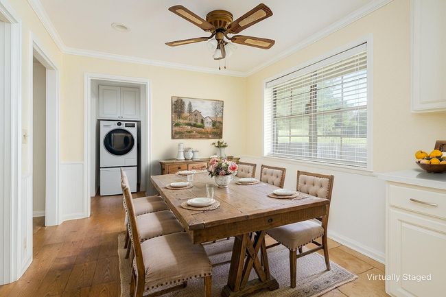 Dining space featuring washer / dryer, ornamental molding, a ceiling fan, and light wood-style floors | Image 24