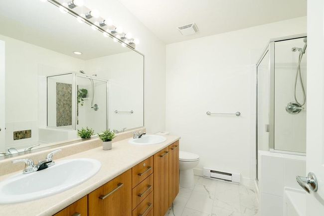Bathroom with a stall shower, visible vents, and a sink | Image 27