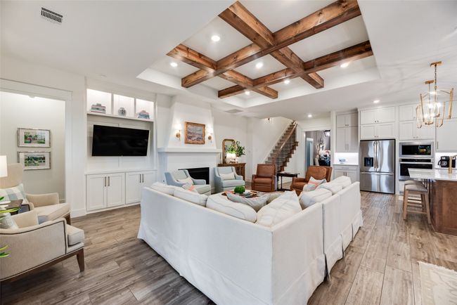 Living area with light wood-type flooring, coffered ceiling, beamed ceiling, recessed lighting, and stairs | Image 9