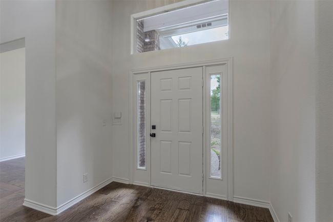 Foyer entrance with dark wood finished floors, a towering ceiling, and baseboards | Image 26
