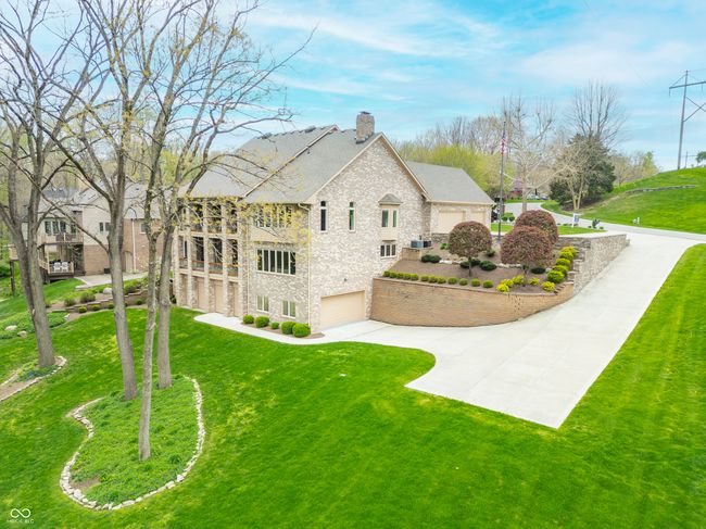 view of home's exterior featuring a chimney, stone siding, a yard, and an attached garage | Image 110