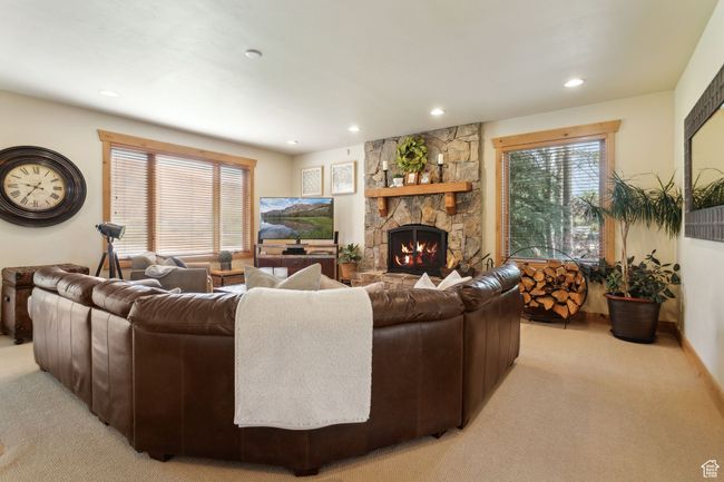 Living area with light carpet, recessed lighting, a stone fireplace, and plenty of natural light | Image 11