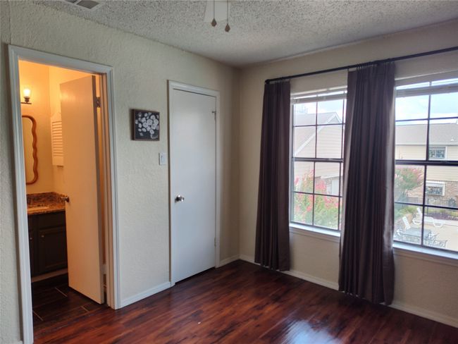 Unfurnished bedroom with ensuite bath, dark hardwood / wood-style flooring | Image 12