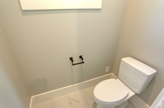 Bathroom with marble look tiles and toilet | Image 31