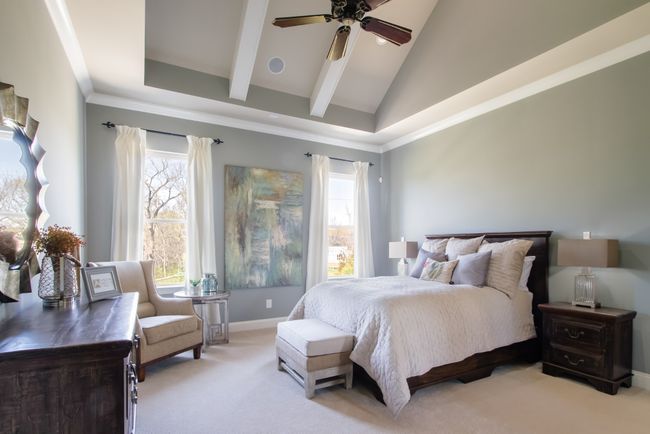 The primary bedroom has vaulted ceilings with wood beams. | Image 33
