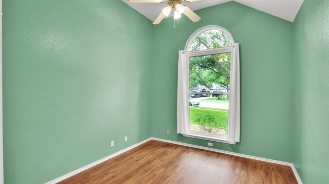 Guest bedroom with vinyl plank finished floors, a ceiling fan, and lofted ceiling | Image 7
