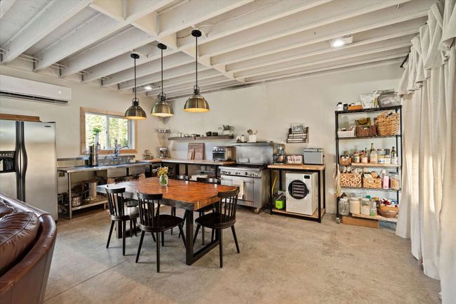 Dining area with a wall unit AC, beam ceiling, and concrete floors | Image 18