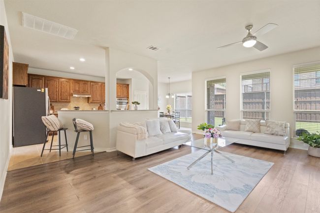 Living room featuring a ceiling fan, light wood-style floors, recessed lighting, arched walkways, and baseboards | Image 8