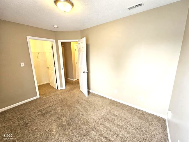 unfurnished bedroom featuring baseboards, visible vents, a spacious closet, and carpet | Image 40