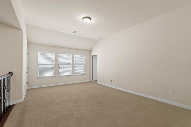 Carpeted empty room featuring lofted ceiling and baseboards | Image 28
