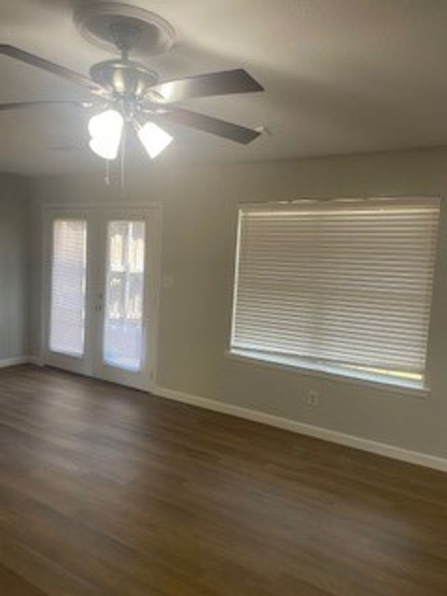 Spare room featuring baseboards, dark wood-type flooring, ceiling fan, and french doors | Image 8