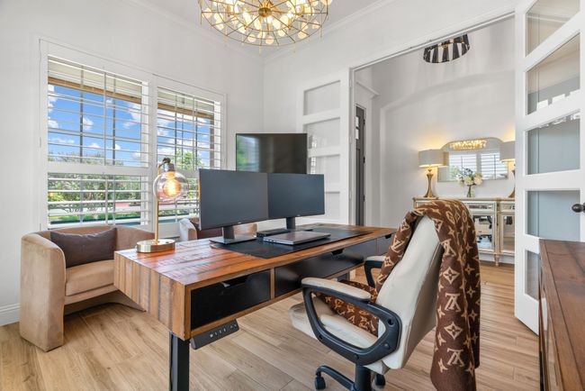Home office featuring ornamental molding, a chandelier, light wood-style floors, and built in features | Image 24