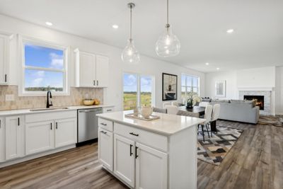 Photo is of the actual home. The kitchen overlooks the dining area and Great Room. | Image 3