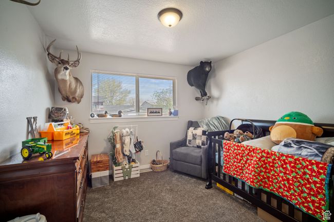 Carpeted bedroom featuring a textured ceiling | Image 12