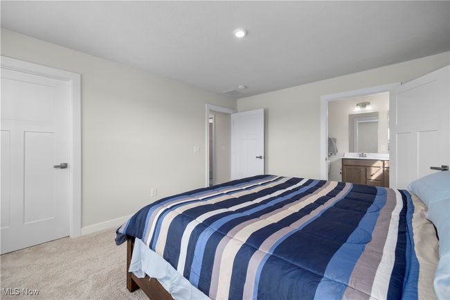 Bedroom featuring a sink, connected bathroom, baseboards, and carpet floors | Image 25