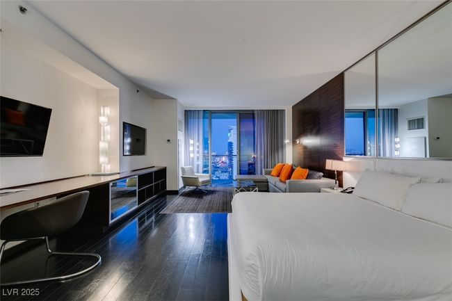 Bedroom with wood finished floors and expansive windows | Image 5