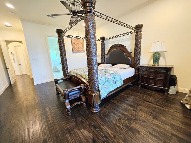Bedroom featuring crown molding, wood finished floors, baseboards, arched walkways, and recessed lighting | Image 22