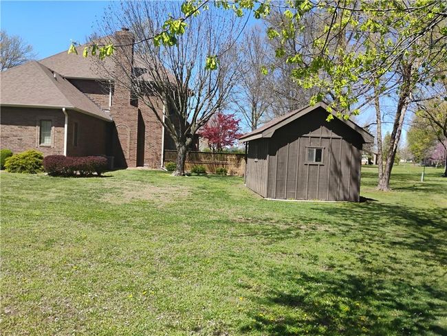 View of yard featuring a storage building and deck | Image 11