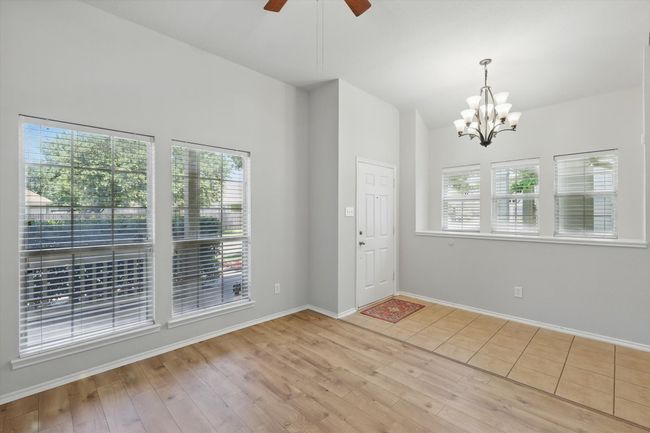 Entrance foyer featuring a chandelier, a ceiling fan, wood finished floors, and lofted ceiling | Image 8