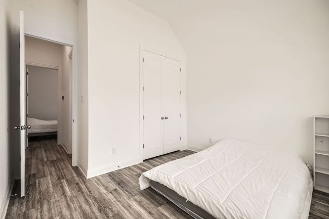Bedroom featuring wood finished floors, a closet, and lofted ceiling | Image 17