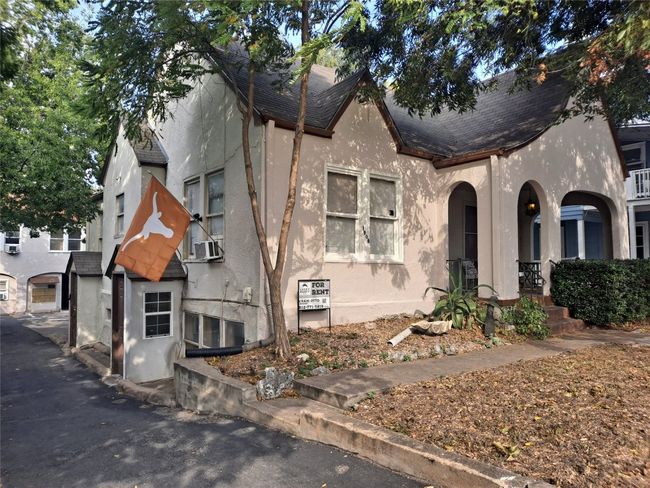 View of front facade featuring stucco siding, a porch, and a shingled roof | Image 6