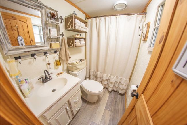 Bathroom with toilet, vanity, a shower with shower curtain, and hardwood / wood-style flooring | Image 20