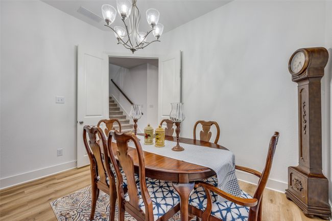 Dining area with a chandelier, stairs, light wood-style flooring, and baseboards | Image 5