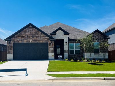 Our Leland floor plan is a beautiful one-story with a cedar garage door and front yard landscaping. | Image 1