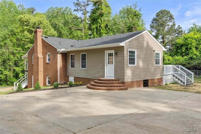 Rear view of house with driveway, a shingled roof, entry steps, and a chimney | Image 35