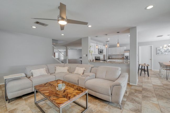 Living room featuring recessed lighting, ceiling fan, a chandelier, and stairway | Image 4