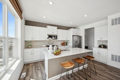 (Photo of model home, finishes will vary) This spacious kitchen includes a large center island, quartz countertops, recessed lighting, LVP wood floors, stainless appliances and more. | Image 2