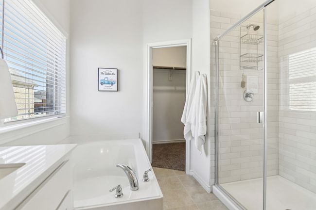 Full bath with a spacious closet, tile patterned floors, a bath, and a stall shower | Image 19