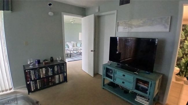 Master bedroom entrance door to carpeted living room with ceiling fan | Image 15