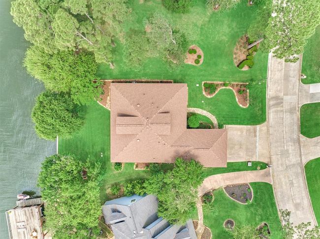 This bird’s-eye view showcases the property’s beautifully maintained landscaping, accented with stone edging throughout. The grounds feature four crepe myrtles, three Texas rose bushes, one Meyer lemon tree, and three vibrant blood orange trees, creating a lush and colorful outdoor setting. | Image 5