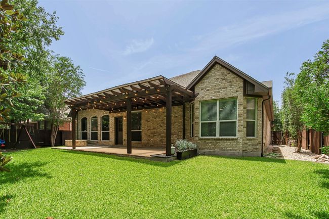 Rear view of house featuring a pergola, a patio area, stone siding, and brick siding | Image 36